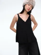 Top negro de tirantes finos con escote en V adornado con encaje delicado. Presenta un corte holgado y terminaciones de encaje en el ruedo.