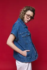 Chaleco de jean oversized color negro, con cuello camisero y cierre frontal con botones metálicos. Presenta un diseño estructurado con costuras reforzadas.
