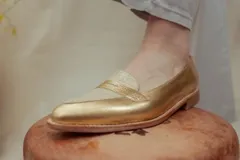Mocasines de cuero plateado con acabado texturado, diseño clásico con costuras visibles y vira de suela natural cosida. Cuenta con taco plano de 2 cm y plantilla anatómica.