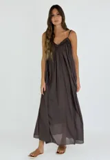 Vestido largo tipo solera de corte holgado, con breteles finos y escote en V con detalle de frunces. Confeccionado en tela liviana y fluida.