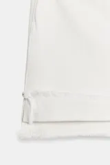 Shorts de jean de algodón, tiro alto, color azul claro desgastado. Presenta cinco bolsillos, cierre frontal con botón metálico y cremallera, y bajo desflecado con vuelta.