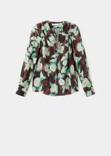 Blusa de gasa con estampado floral en tonos verdes y marrones, cuello escotado con cierre de lazo y mangas largas con puños abotonados.