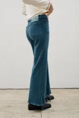 Jean de corte recto y tiro medio, confeccionado en denim de algodón. Presenta costuras verticales frontales y ruedo deshilachado.