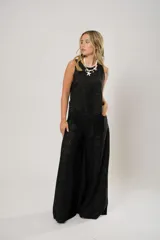 Pantalón negro súper campana de tiro medio en lino con bordados, con bolsillos delanteros y en la espalda. Cierre frontal con cremallera y botón.