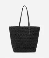 Bolso de playa tejido en paja de papel color negro, con asas de cuero sintético y cierre a presión. Incluye borla decorativa colgante.