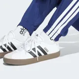 Pantalón Adidas Essentials 3 Rayas de corte clásico, color azul, con cintura elástica con cordón ajustable, bolsillos frontales y puños elásticos. Presenta las emblemáticas tres tiras blancas a los lados de las piernas y el logo de la marca bordado en blanco.
