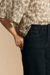 Jean de tiro alto y pierna ancha, confeccionado en denim azul oscuro con costuras a contratono. Presenta un diseño de corte recto y holgado.