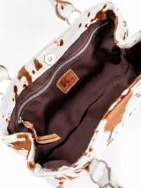 Cartera tipo baguette color marrón, de formato rectangular alargado y diseño rígido, con doble asa de hombro y argollas metálicas decorativas. Confeccionada en cuero.