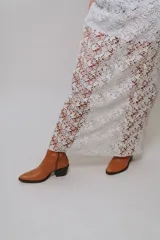 Falda larga blanca de encaje con diseño floral transparente y forro corto interior.