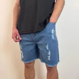 Bermuda de jean estilo jogger con efecto desgastado, roturas frontales y ruedo desflecado.