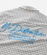 Camisa de manga corta para hombre con diseño boxy, confeccionada en tricolina de algodón con estampado de cuadros y textura sutil. Presenta cuello camisero, cierre frontal con botones y un bolsillo aplicado en el pecho.