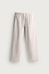 Pantalón de corte relajado confeccionado en una mezcla de algodón y lino. Presenta cintura elástica con cordón ajustable, bolsillos laterales y bolsillos traseros de vivo.
