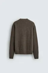 Jersey de corte relajado confeccionado en una mezcla de algodón y lana. Presenta cuello redondo, manga larga y acabados en rib en puños y bajo.