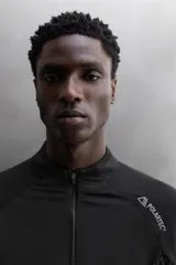 Sudadera negra de tejido técnico Polartec© con interior en estructura waffle. Tiene cuello alto con cremallera, mangas largas con puños ajustables con abertura para el pulgar y logo Polartec© bordado en el hombro.