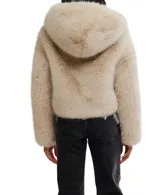 Chaqueta corta de pelo sintético color beige claro, con capucha fija y cierre frontal.