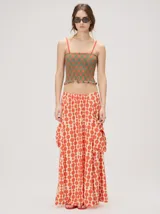 Falda midi de tiro alto y silueta evasé, confeccionada en algodón con diseño estampado geométrico en tonos verdes, naranjas y celestes. Cuenta con caída fluida, ruedo ligeramente acampanado y dos bolsillos cuadrados laterales.