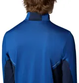 Remera de manga larga Columbia con cierre frontal parcial, cuello alto y orificios para pulgares en los puños. Presenta un diseño técnico con paneles laterales en un tono de azul más oscuro y tecnología Omni-Wick para gestión de la humedad.