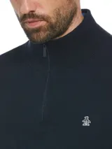 Sweater de punto color azul marino, con cuello alto y cierre frontal de un cuarto, manga larga y el clásico logo del pingüino bordado en el pecho.