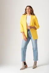 Blazer amarillo de corte entallado, con mangas tres cuartos con botón decorativo, solapas y bolsillos delanteros.