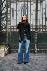 Jean de tiro alto con silueta amplia y pierna ancha, confeccionado en denim de algodón. Cuenta con cierre frontal de botón y cremallera, además de bolsillos funcionales en la parte delantera y trasera.