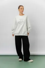 Buzo oversize de algodón frizado color gris melange, con cuello redondo y puños y cintura tejidos. Presenta un bordado tono sobre tono de Garfield en el centro del pecho.