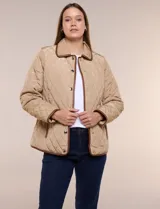 Campera matelaseada Michael Kors, de color beige con ribetes de ecocuero marrón. Cuenta con cuello con solapa, cierre frontal con broches metálicos, bolsillos laterales con cierre y mangas largas.