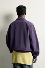 Cazadora regular fit de algodón color violeta, con cuello solapa, cierre frontal de cremallera, bolsillos de vivo en la cadera y acabados elásticos en puños y cintura.