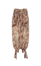Pantalon balloon de tul con estampado abstracto en tonos marrones y beige, pretina ancha fruncida, forro interior y bajos ajustados con tiras para atar en los tobillos.