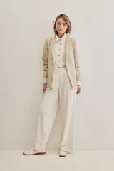 Pantalón negro de pierna ancha y calce fluido, con pinzas delanteras y bolsillos laterales.