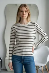 Sweater de hilo de punto con diseño de rayas horizontales negras sobre fondo blanco, cuello redondo y mangas largas.