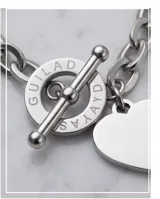 Pulsera de cadena de eslabones de acero con cierre de barra y argolla grabada. Incluye un dije en forma de corazón con inscripción grabada.