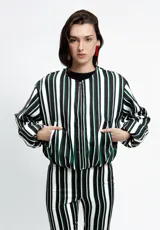 Campera tipo bomber corta, con cierre frontal, cuello a la base, bolsillos ojal y mangas largas abullonadas. Presenta un diseño estampado a rayas verticales en tonos blanco, negro y verde.