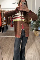 Saco tejido de punto con diseño de ochos, con bloques de color en marrón, blanco, rojo y amarillo neón. Presenta mangas largas y cierre frontal con botones.