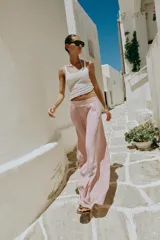 Pantalón fluido de tiro alto con cintura elástica y pernera ancha, de color rosado.