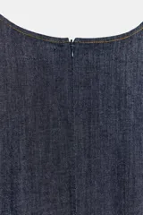 Vestido corto de denim azul oscuro, con cuello redondo, mangas amplias de largo tres cuartos y cintura elástica con cinturón integrado del mismo tejido. Presenta costuras a contraste y cierre posterior con cremallera oculta.