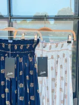 Pantalón blanco con estampado dorado, de corte amplio y cintura elástica.