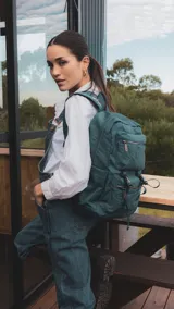 Mochila de gran capacidad color beige, confeccionada en nylon. Cuenta con múltiples compartimentos frontales con cierre y hebillas ajustables, bolsillos laterales y correas acolchadas para mayor comodidad.