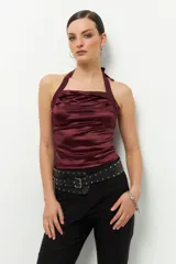 Top negro de satén con cuello halter y espalda descubierta.