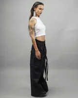 Pantalón cargo negro de gabardina, corte amplio, con múltiples bolsillos y tiras ajustables.