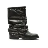 Bota de caña media con diseño slouchy, confeccionada en cuero sintético negro. Presenta detalles de tachas metálicas plateadas en la parte superior de la caña y en la base del tobillo, con suela plana y punta redondeada.