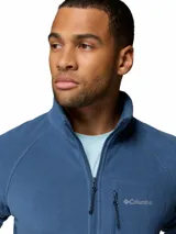 Campera polar de la marca Columbia, modelo Fast Trek II. Presenta cuello alto, cierre frontal completo, bolsillos laterales con cierre y un bolsillo adicional con cierre en el pecho, donde se encuentra el logo de la marca bordado.