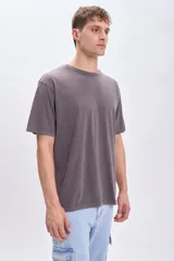 Remera de manga corta gris oscuro con estampa circular en la espalda con un sol en el centro y la frase "Catch the sun, chose the surf".