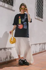 Remera negra de corte holgado con estampado de encendedor, cenicero, pipa y paquete de cigarrillos.