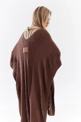 Ruana de punto color beige con detalles texturizados y tramados abiertos, ligera y versátil.