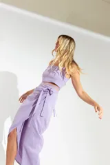 Pollera midi fucsia con corte irregular, abertura lateral y sistema de ajuste envolvente con lazo.