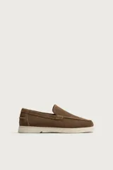 Mocasines casuales para hombre, fabricados en piel con acabado en serraje color marrón, de corte liso con detalle de bordón y suela blanca a contraste.