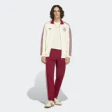 Campera deportiva Adidas Originals de la selección de España, color blanco con detalles en bordó. Presenta cuello tipo polo, cierre frontal con cremallera, las icónicas tres tiras en las mangas y el escudo de la selección junto al logo del trébol en el pecho.