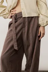 Pantalón de corte ancho y holgado, de color negro, con diseño estructurado y cinturón ajustable integrado en la cintura.