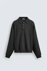 Sudadera tipo polo de corte regular, confeccionada en tejido con acabado cepillado. Presenta cuello solapa con cierre frontal de tres botones, manga larga y terminaciones en rib en puños y ruedo.