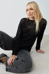 Sweater negro de tejido de punto con calado en la parte superior delantera y en los hombros.